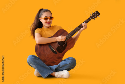 Young woman playing guitar ...