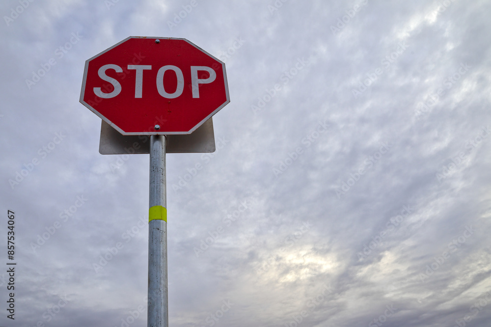 STOP sign isolated against overcast, cloudy sky at dusk, dawn STOP sign isolated against overcast, cloudy sky at dusk, dawn