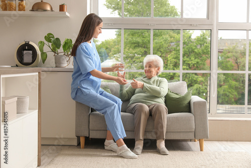 Young nurse giving pills an...