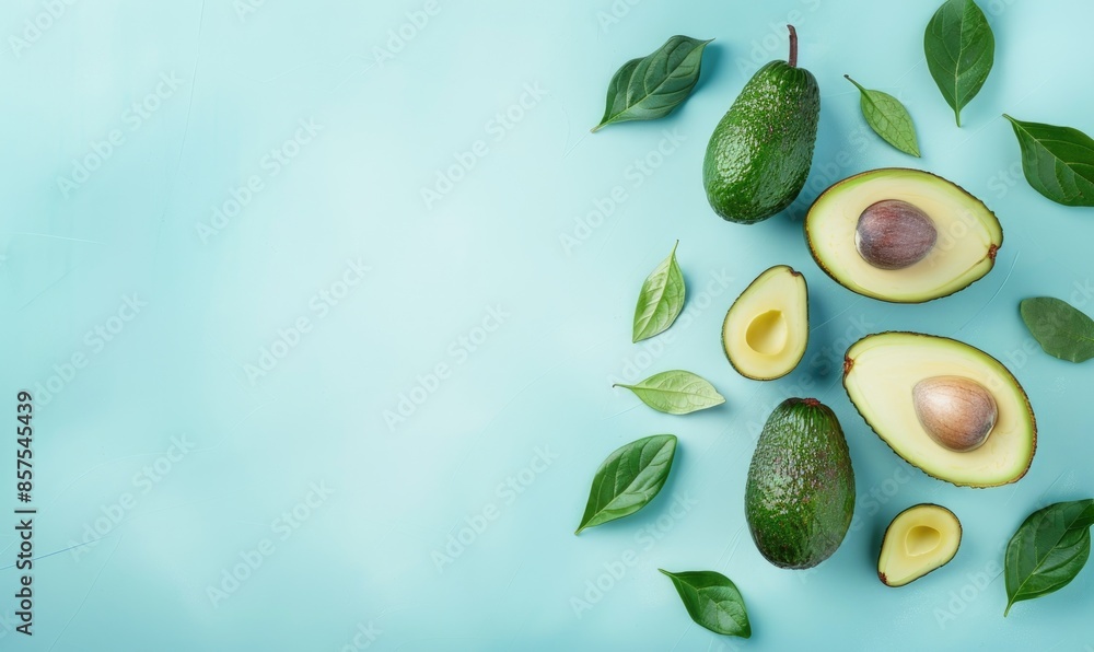 Whole avocado with leaves on a pastel blue background Whole avocado with leaves on a pastel blue background