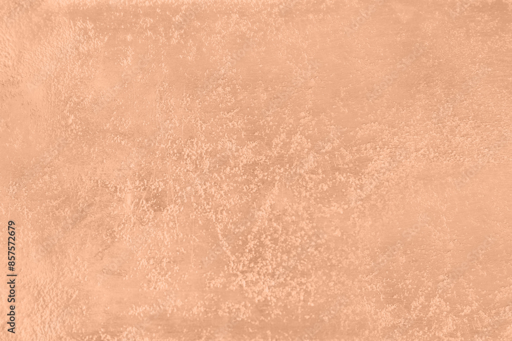 Fototapeta premium Stone surface of peach fuzz color, top view. Trendy shade of 2024 year