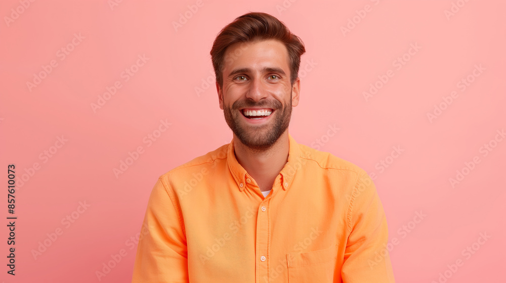 Obraz premium Smiling man in orange shirt against pink background.