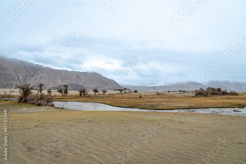 The valley between mountains on a cloudy day. A dried river terrain of Shyok river in Nubra Valley in Ladakh Region of Indian Himalayan territory.A Barren landscape of Cold dessert in Himalaya Valley.