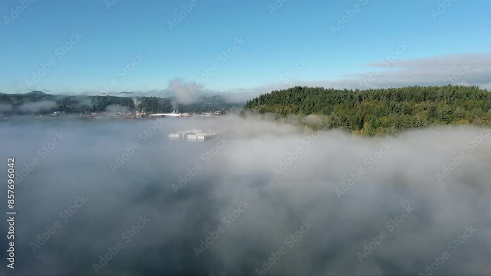 Aerial view from a drone hovering above haze on Puget Sound, showcasing the silhouette of the distant mountain range. The atmospheric conditions create a peaceful and picturesque scene. Aerial view from a drone hovering above haze on Puget Sound, showcasing the silhouette of the distant mountain range. The atmospheric conditions create a peaceful and picturesque scene.