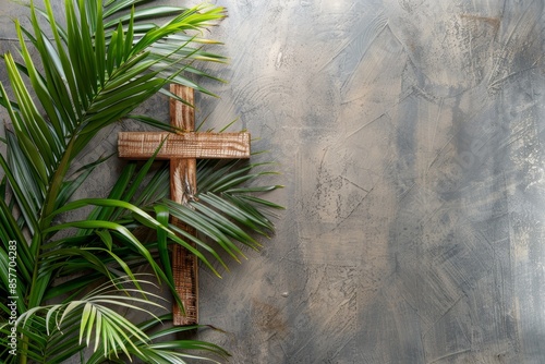 Palm sunday concept with palm tree branches on left side with wooden christian cross and copy space for text photo