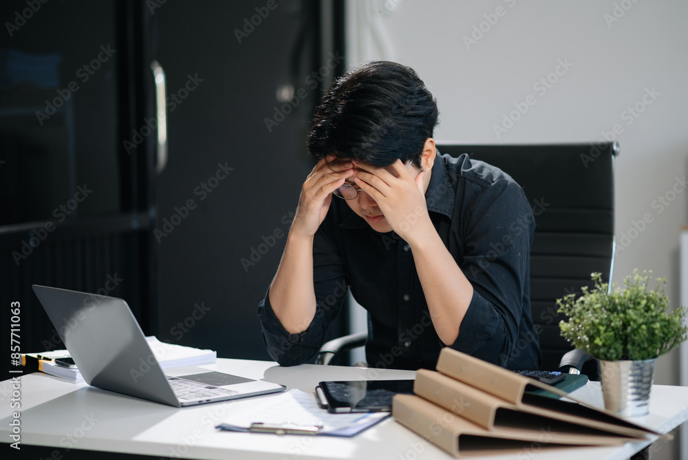 Businessman who is tired and overthinking from working with tablet and laptop Businessman who is tired and overthinking from working with tablet and laptop