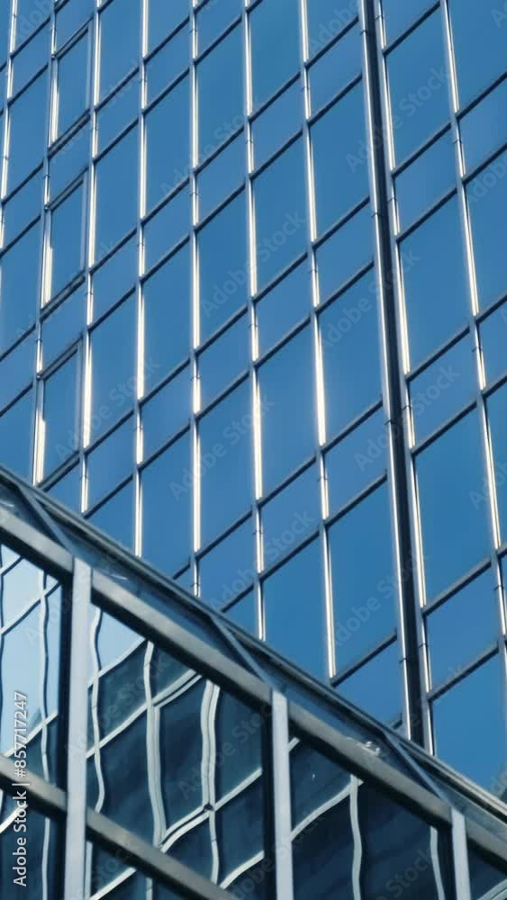 Abstract modern business architecture. Walls made of glass and steel with reflections of buildings and blue sky. Abstract modern business architecture. Walls made of glass and steel with reflections of buildings and blue sky.