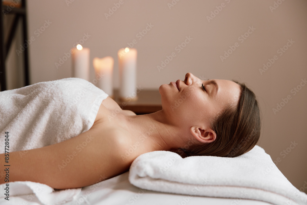 Side view of peaceful woman relaxing in spa salon after massage Side view of peaceful woman relaxing in spa salon after massage