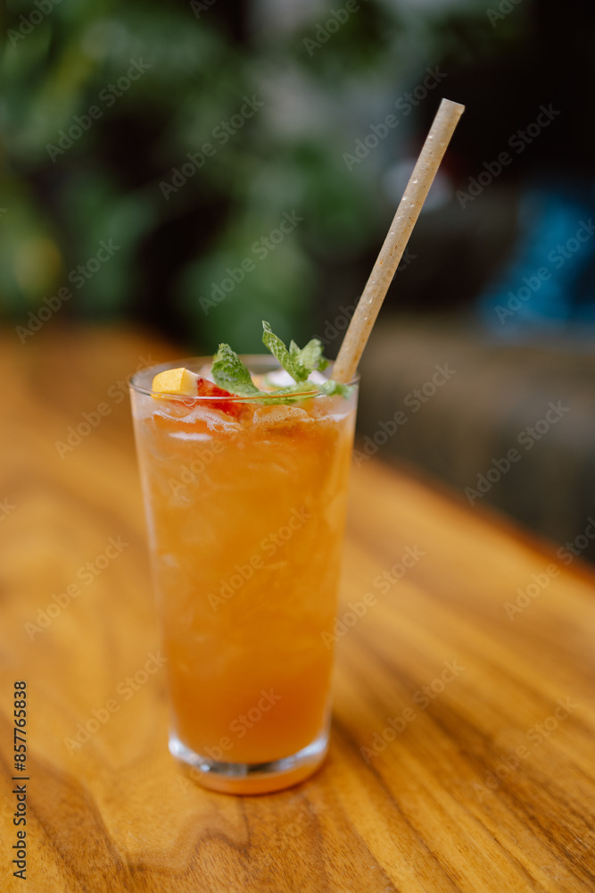 Refreshing orange cocktail with a garnish of mint on a wooden table. Refreshing orange cocktail with a garnish of mint on a wooden table.