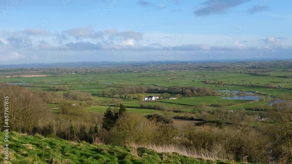 Scenic panoramic landscape over the Somerset Levels with green fields, hedges and lakes of water in Glastonbury, England UK Scenic panoramic landscape over the Somerset Levels with green fields, hedges and lakes of water in Glastonbury, England UK
