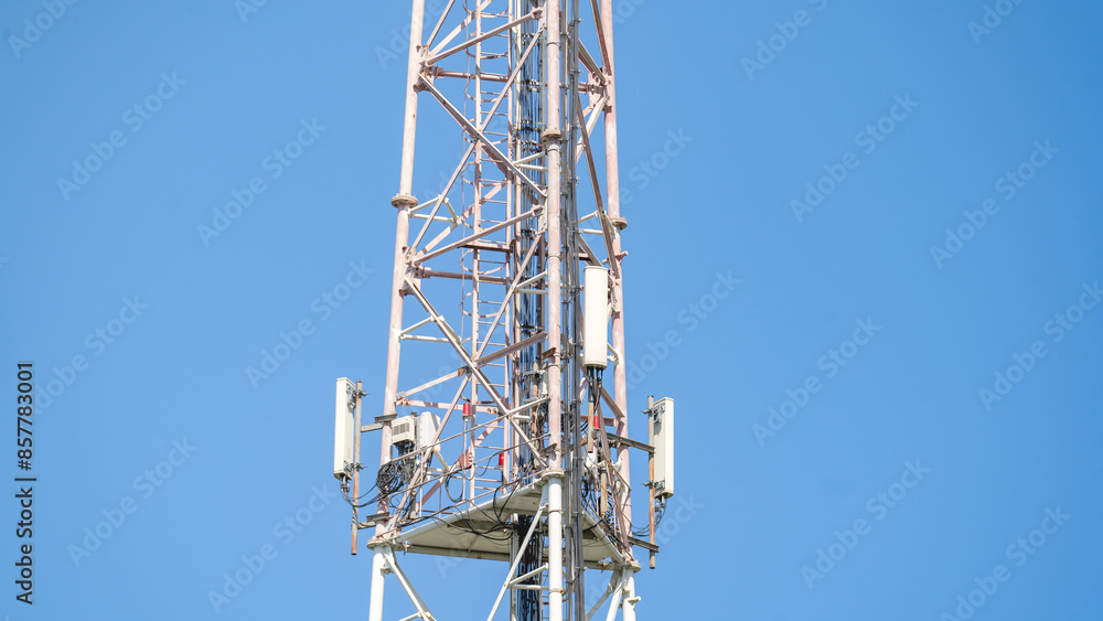 Cell tower with antennas against a blue clear sky, concept of telecommunications equipment, high-speed mobile Internet networks, 5G, 4G, 3G Cell tower with antennas against a blue clear sky, concept of telecommunications equipment, high-speed mobile Internet networks, 5G, 4G, 3G