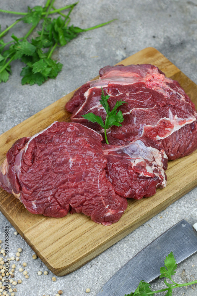 Daging sapi mentah or raw beef on preparation for cooking with some spice. Beef on Eco friendly package and chopping board with wooden rustic background. Daging sapi mentah or raw beef on preparation for cooking with some spice. Beef on Eco friendly package and chopping board with wooden rustic background.
