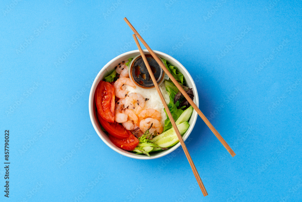 Top view of fresh poke bowl on blue background Top view of fresh poke bowl on blue background