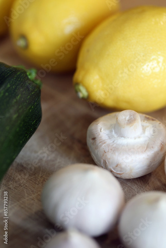 Scandinavian summer, fall season cuisine. Ingredients for a healthy meal: potatoes, garlic, zucchini and lemons on a wooden rustic cutting board. Fresh raw vegetables from season's harvest. Closeup.