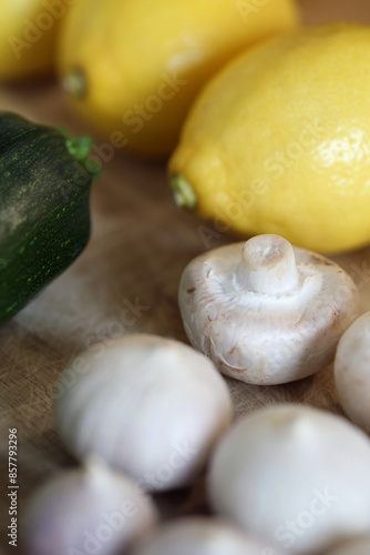 Scandinavian summer, fall season cuisine. Ingredients for a healthy meal: potatoes, garlic, zucchini and lemons on a wooden rustic cutting board. Fresh raw vegetables from season's harvest. Closeup.