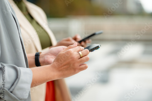 Close-Up of Women Entrepreneurs Using Smartphones Outdoors for Business Communication