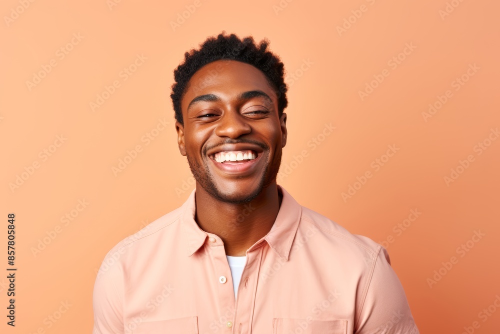 Portrait photo of a smiling man winking on a pastel peach background Portrait photo of a smiling man winking on a pastel peach background