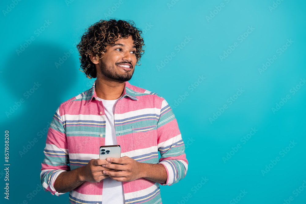 Photo of cheerful nice man wear trendy striped clothes look offer empty space isolated on cyan color background Photo of cheerful nice man wear trendy striped clothes look offer empty space isolated on cyan color background