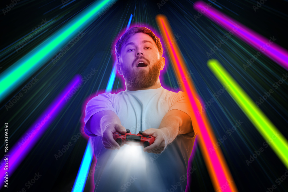 Excited man playing video game with controller on dark background. Bright light traces, motion blur effect Excited man playing video game with controller on dark background. Bright light traces, motion blur effect