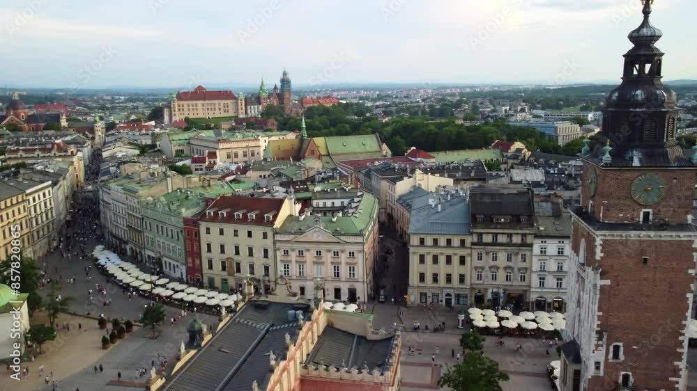Drone shot of town hall tower in main square of Krakow Old Town with busy street and apartments Drone shot of town hall tower in main square of Krakow Old Town with busy street and apartments