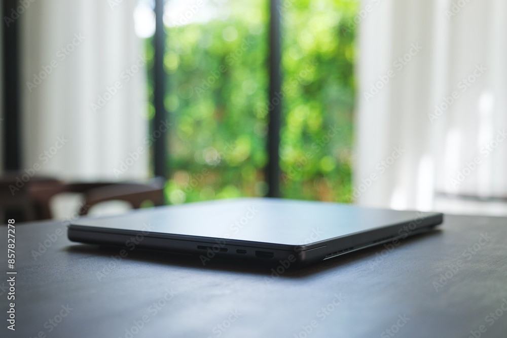 A single laptop computer on wooden table A single laptop computer on wooden table