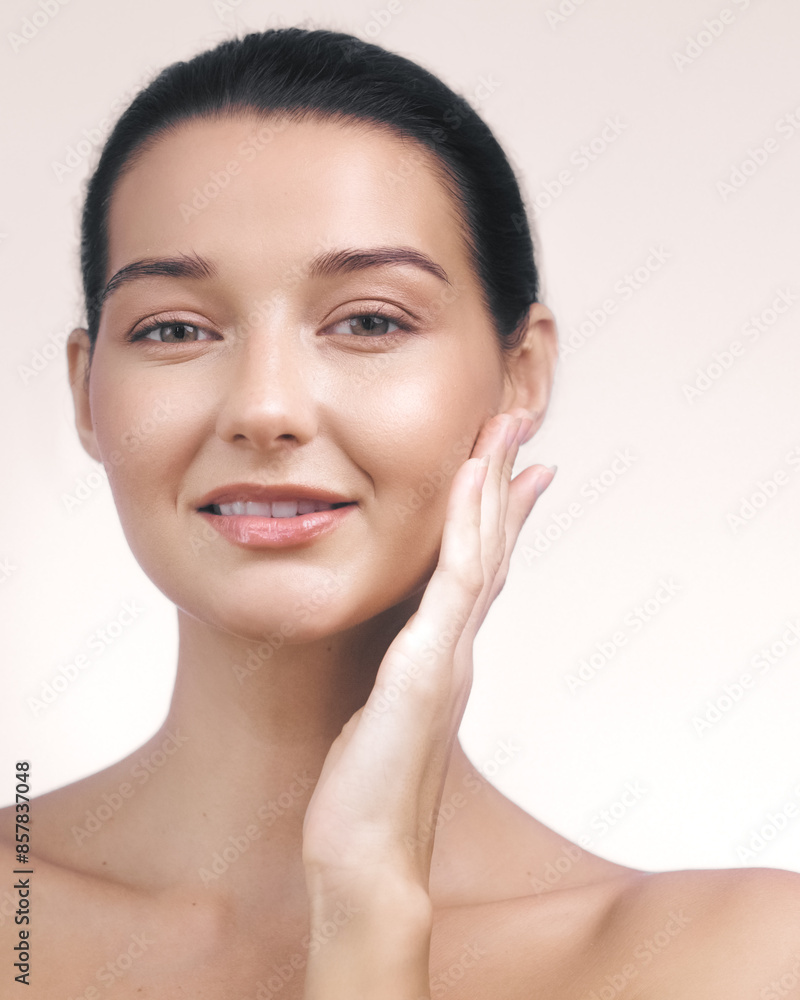 Young Woman with Glowing Skin Touching Her Face on Beige Background Young Woman with Glowing Skin Touching Her Face on Beige Background