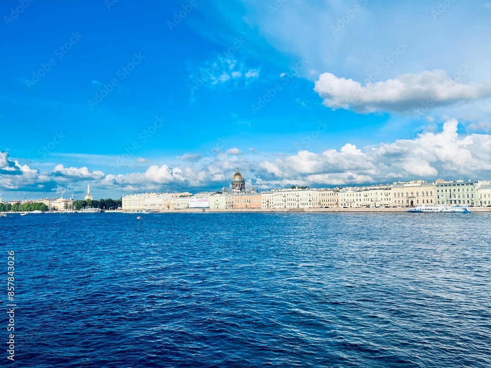 Fototapeta premium Fantastic white clouds at the city river, city river view, summer day