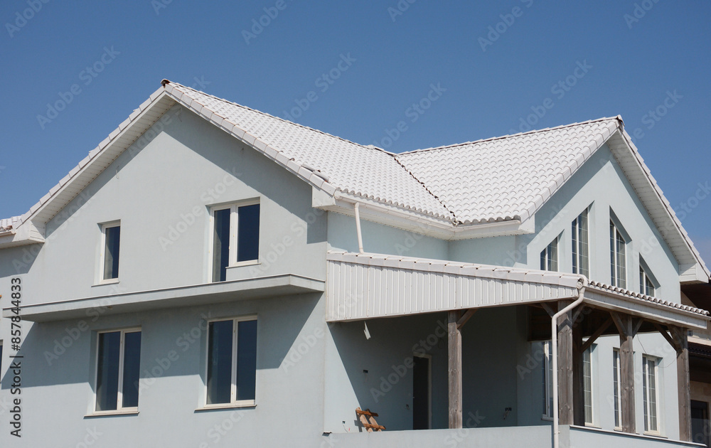 Enerergy efficiency moder house under construction with white roof tiles, white rain gutters and white facade walls. Enerergy efficiency moder house under construction with white roof tiles, white rain gutters and white facade walls.