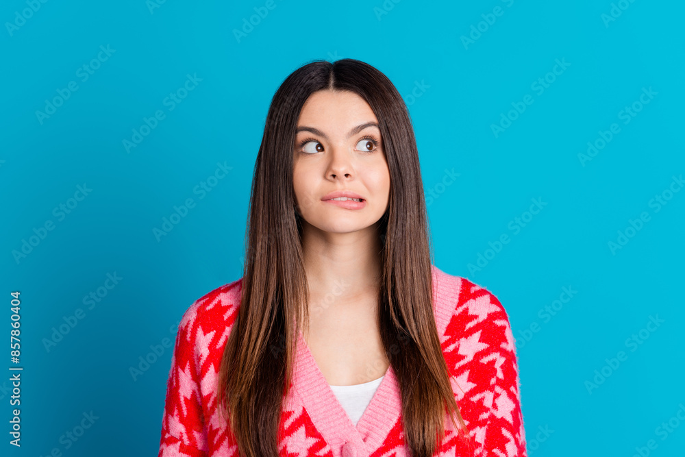 Photo of funny woman with straight hairstyle dressed knitwear cardigan biting lips look empty space isolated on blue color background Photo of funny woman with straight hairstyle dressed knitwear cardigan biting lips look empty space isolated on blue color background