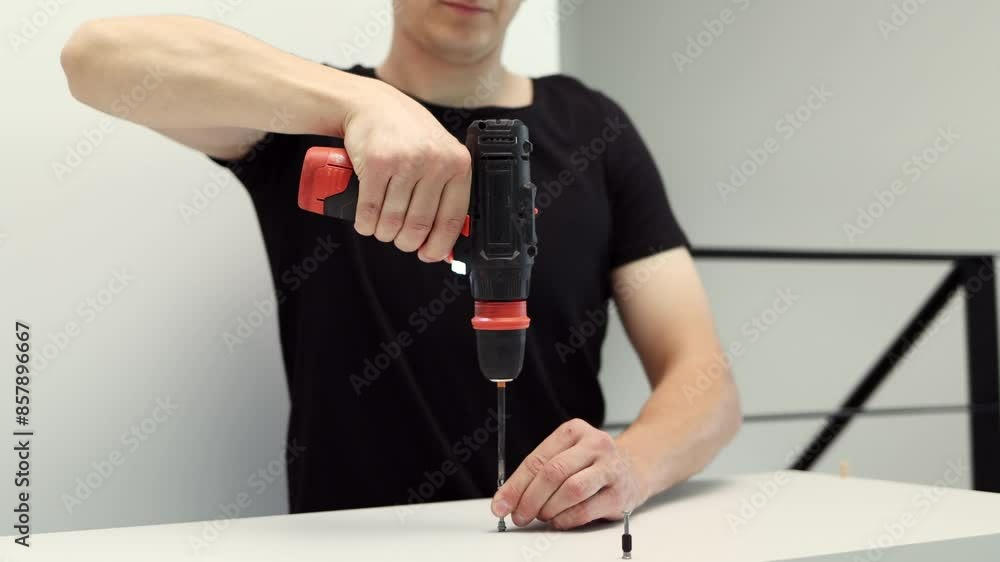 A young craftsman assembles furniture fittings. Screwing the confirmat close-up. Professional furniture assembling. Installation of new furniture. Furniture assembly. 4k footage. A young craftsman assembles furniture fittings. Screwing the confirmat close-up. Professional furniture assembling. Installation of new furniture. Furniture assembly. 4k footage.