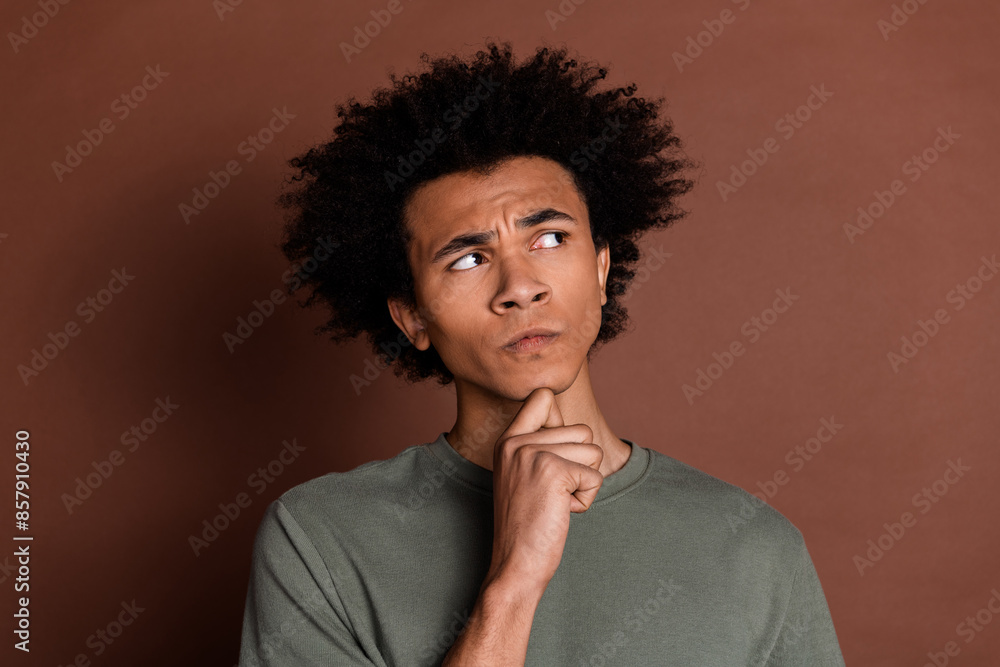 Portrait photo of young funky guy with curly haircut wearing gray t shirt contemplate looking mockup isolated on brown color background Portrait photo of young funky guy with curly haircut wearing gray t shirt contemplate looking mockup isolated on brown color background