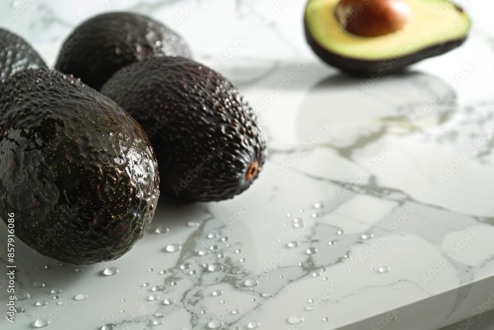 Fresh whole avocados with water droplets on a kitchen countertop Fresh whole avocados with water droplets on a kitchen countertop