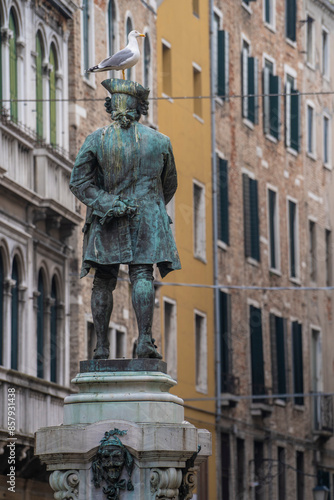 Vintage Statue of Carlo Goldoni from behind, seagull on top of statue head, Campo San Bartolomeo, Venice, Italy 04.01.2024
