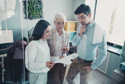 Photo of business people reading document clipboard report in modern workplace