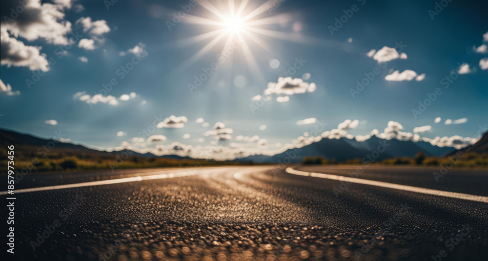 Fototapeta premium Road in the mountains with blue sky and white clouds in background.