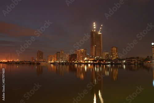 Manila cityscape at night from sea with reflections