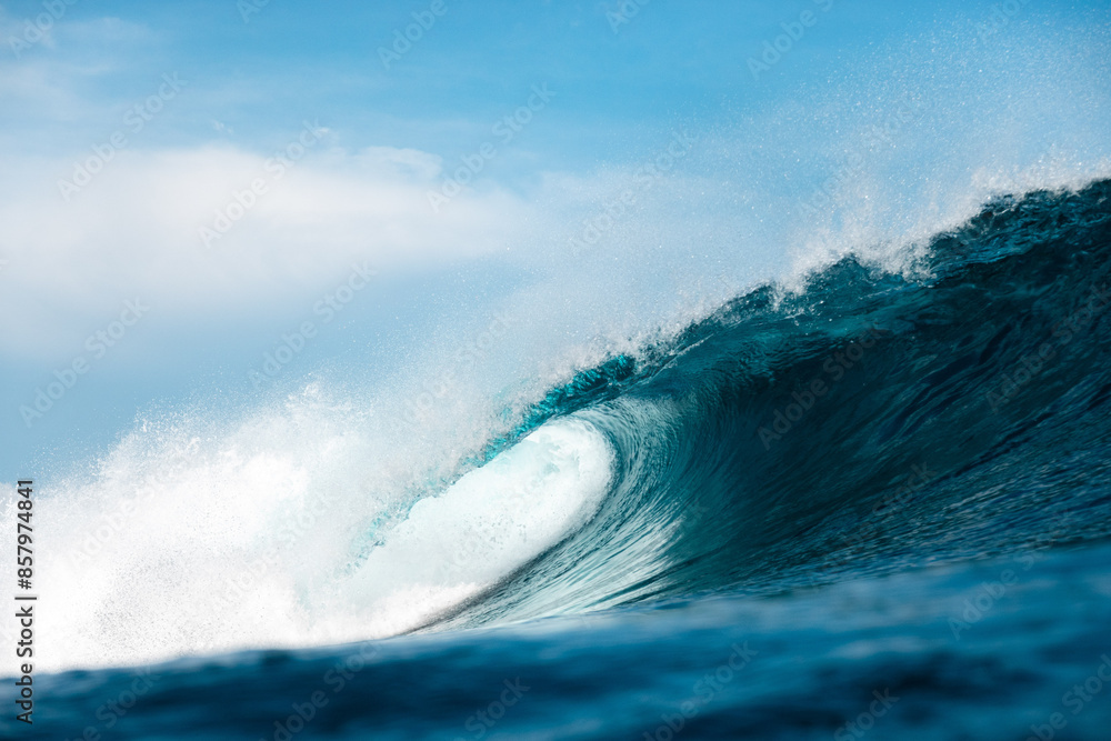 Barreling Wave breaks over coral reef on a clear blue day 