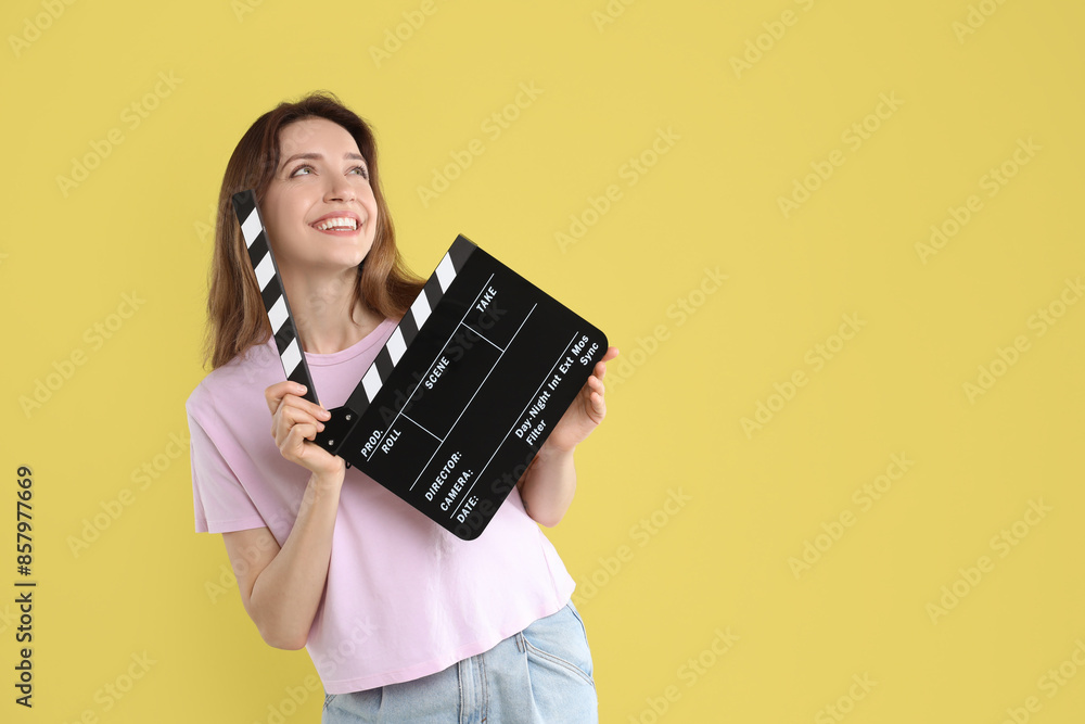Making movie. Smiling woman with clapperboard on yellow background. Space for text Making movie. Smiling woman with clapperboard on yellow background. Space for text