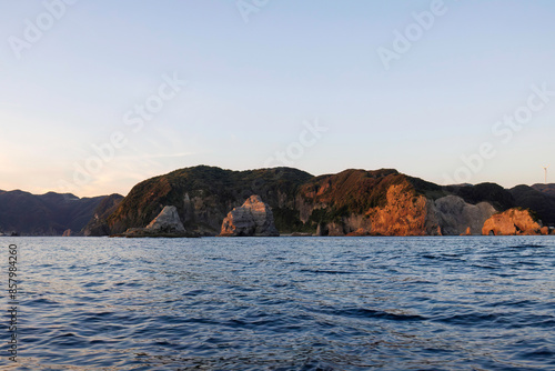 漁船に乗って、中木沖の太平洋へサンセットクルージングに出航。 沖から眺める、夕焼けの中木港。日本国静岡県伊豆半島賀茂郡南伊豆町中木から渡し船で渡るヒリゾ浜にて。 2022年10月撮影。 