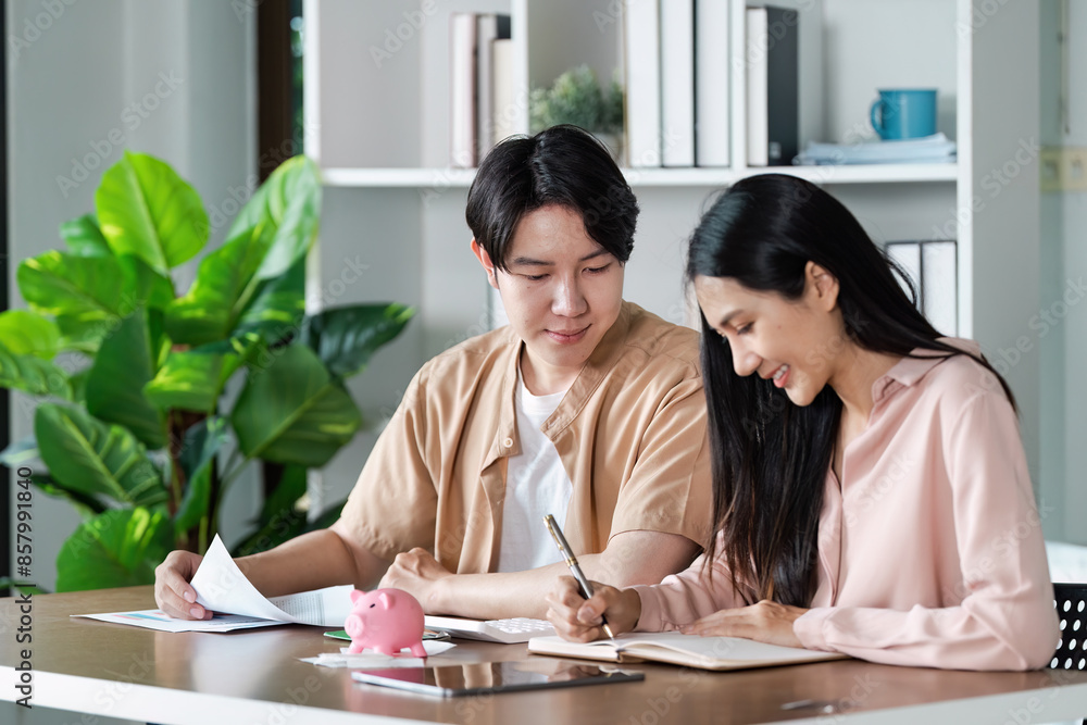 Young Couple Planning savings financial Together at Home with Documents and Piggy Bank on Desk Young Couple Planning savings financial Together at Home with Documents and Piggy Bank on Desk