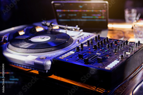 A close-up view of a professional DJ mixing console with various knobs and sliders. photo