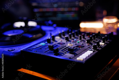 A close-up view of a professional DJ mixing console with various knobs and sliders. photo