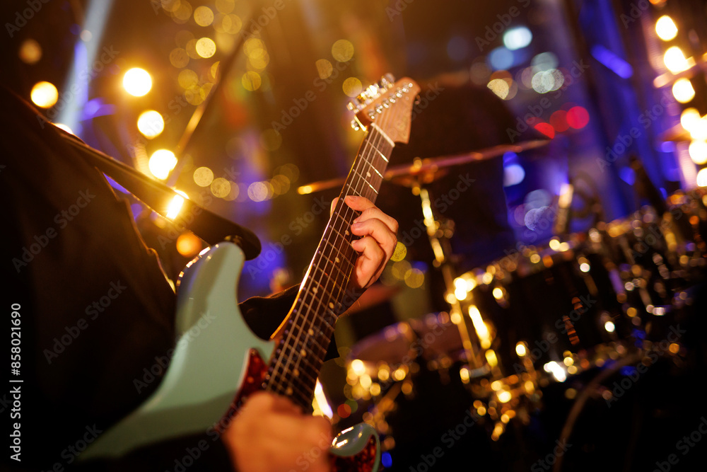 Naklejka premium A guitarist plays a chord on an electric guitar during a rock band performance