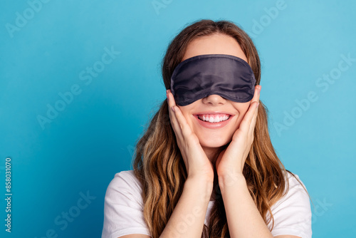 Photo of positive nice cute girl wear white stylish pajama arms touch cheeks isolated on blue color background