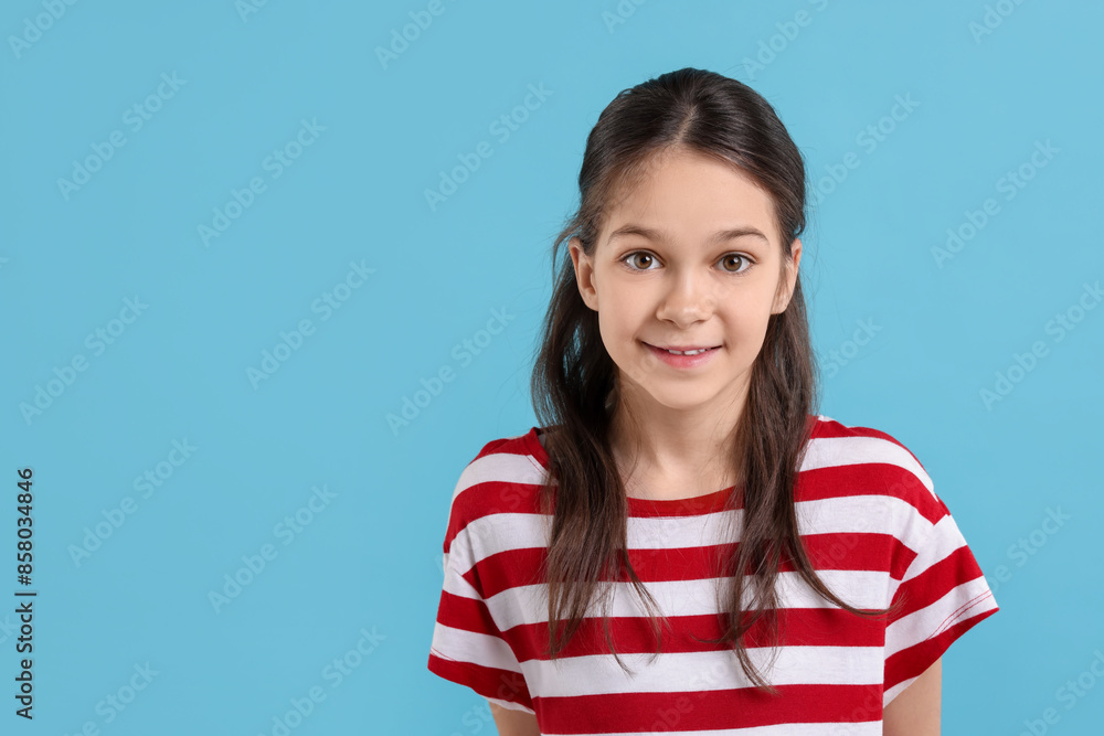 Portrait of beautiful girl on light blue background, space for text