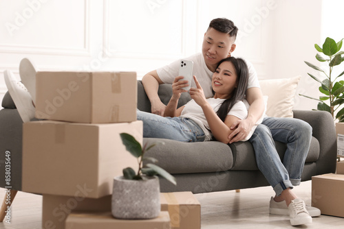 Happy couple with smartphone in their new apartment © New Africa