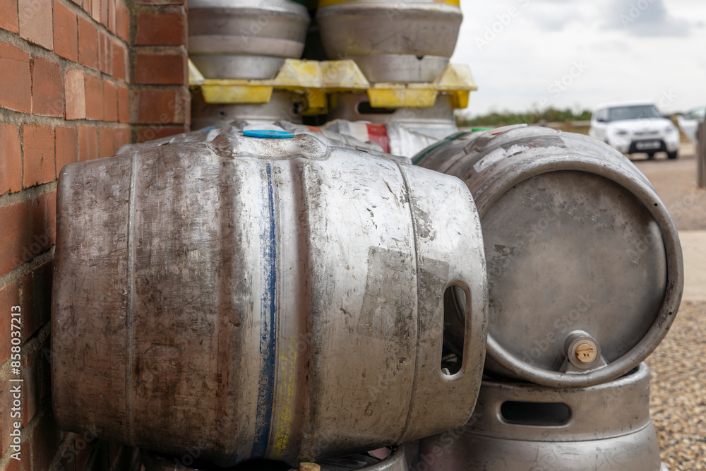 Metal beer barrels kegs beside brewery wall blurry background Metal beer barrels kegs beside brewery wall blurry background