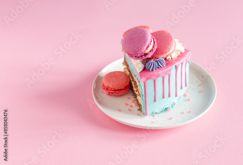 piece of cake with pink and blue decor on white plate on pink background