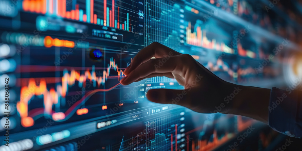 A hand interacts with an illuminated digital screen displaying complex financial graphs and stock market data, indicating active engagement in trading or investment analysis. A hand interacts with an illuminated digital screen displaying complex financial graphs and stock market data, indicating active engagement in trading or investment analysis.