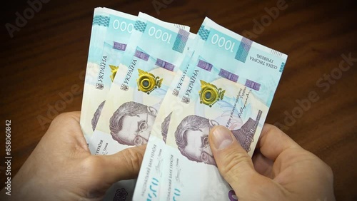 Cash counting. Currency exchange. Hands holds banknotes. Converting cash Ukrainian money. Man holds thousand hryvnia bills in his hands. New paper thousand hryvnia bills. Slow Motion video photo